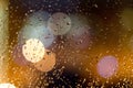 Rain falls on the window and night lightsÃÂ  in light bokeh, city life at night in the rainy season abstract background, a drop of Royalty Free Stock Photo